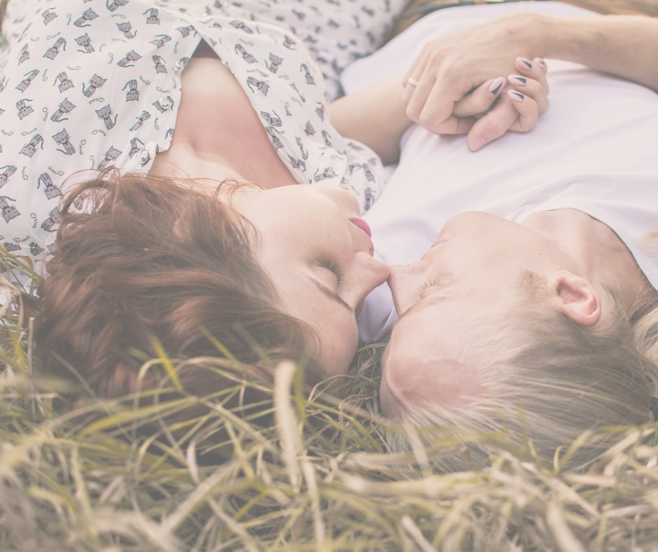 Verliefd koppel hand in hand liggend in hooi